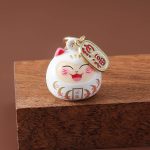 Porte-cle-maneki-neko-daruma-en-email-avec-clochette-doree-et-motifs-floraux-picture-4