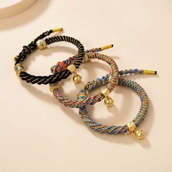 Bracelet en tissu tressé avec perles décoratives dorées et clochette en métal doré ajustable