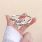 Bracelet lotus en argent tibétain avec motif de fleurs ciselées en relief et inscription en sanskrit