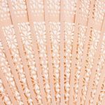 Éventail japonais traditionnel en bois de santal aux découpes florales et géométriques ajourées
