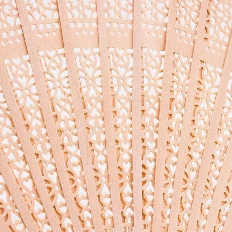 Éventail japonais traditionnel en bois de santal aux découpes florales et géométriques ajourées