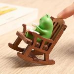 Figurine de grenouille en résine dans un fauteuil à bascule miniature